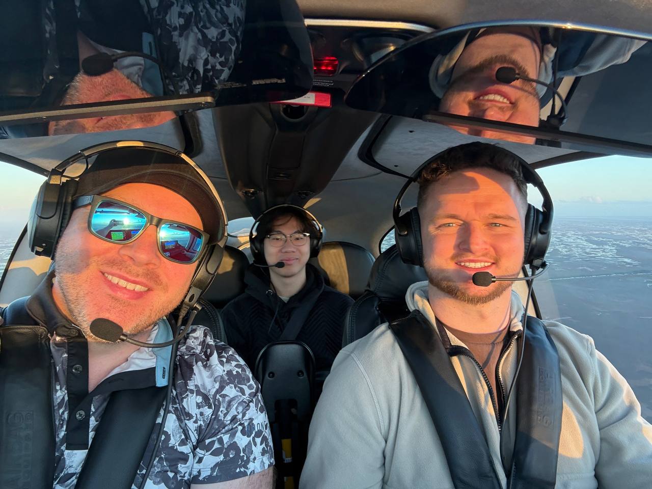 Dawson Gant in the cockpit of a private plane during golden hour, wearing aviation headsets
