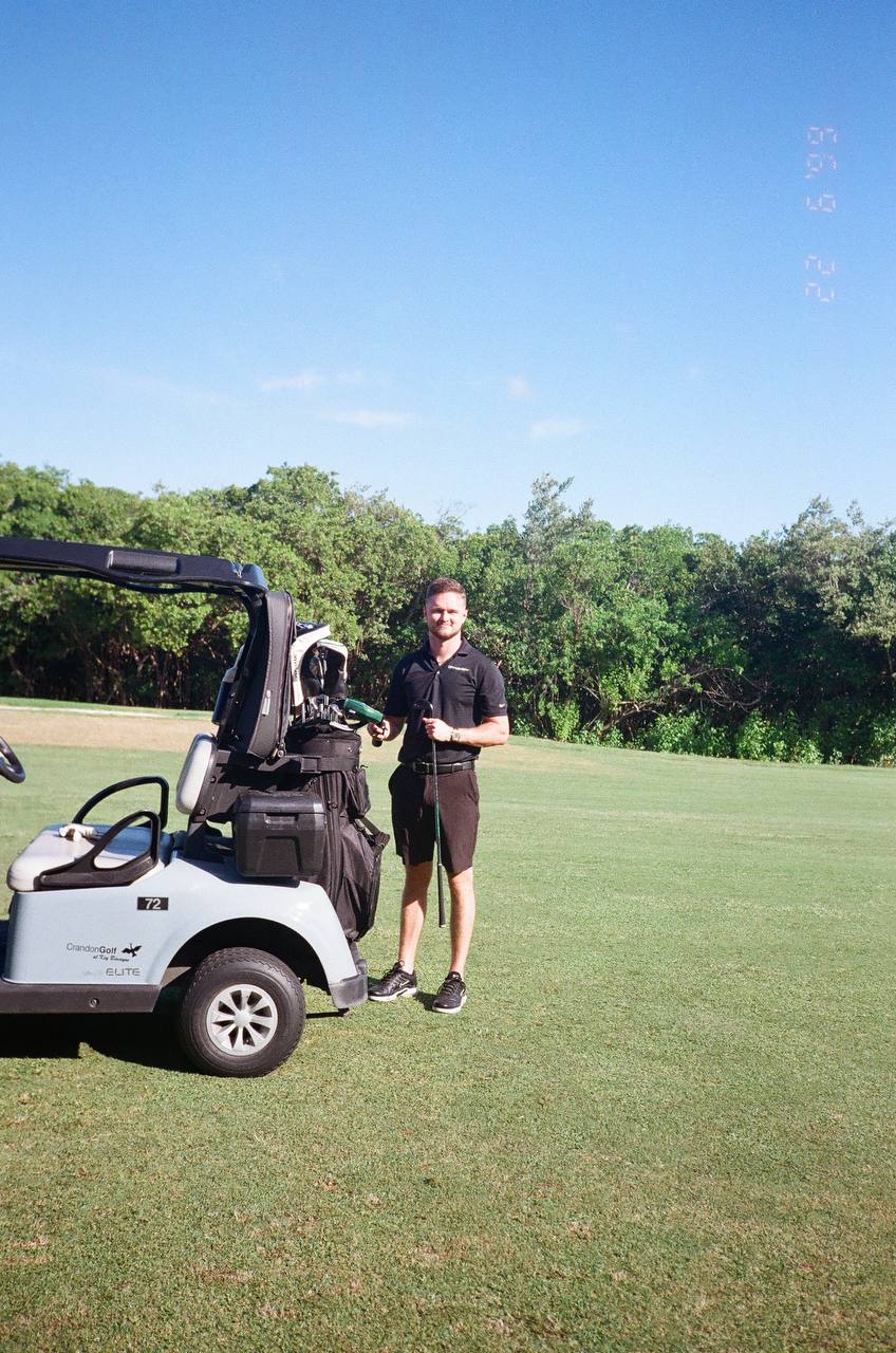 Dawson Gant at Crandon Golf in Miami, wearing a black polo beside a golf cart